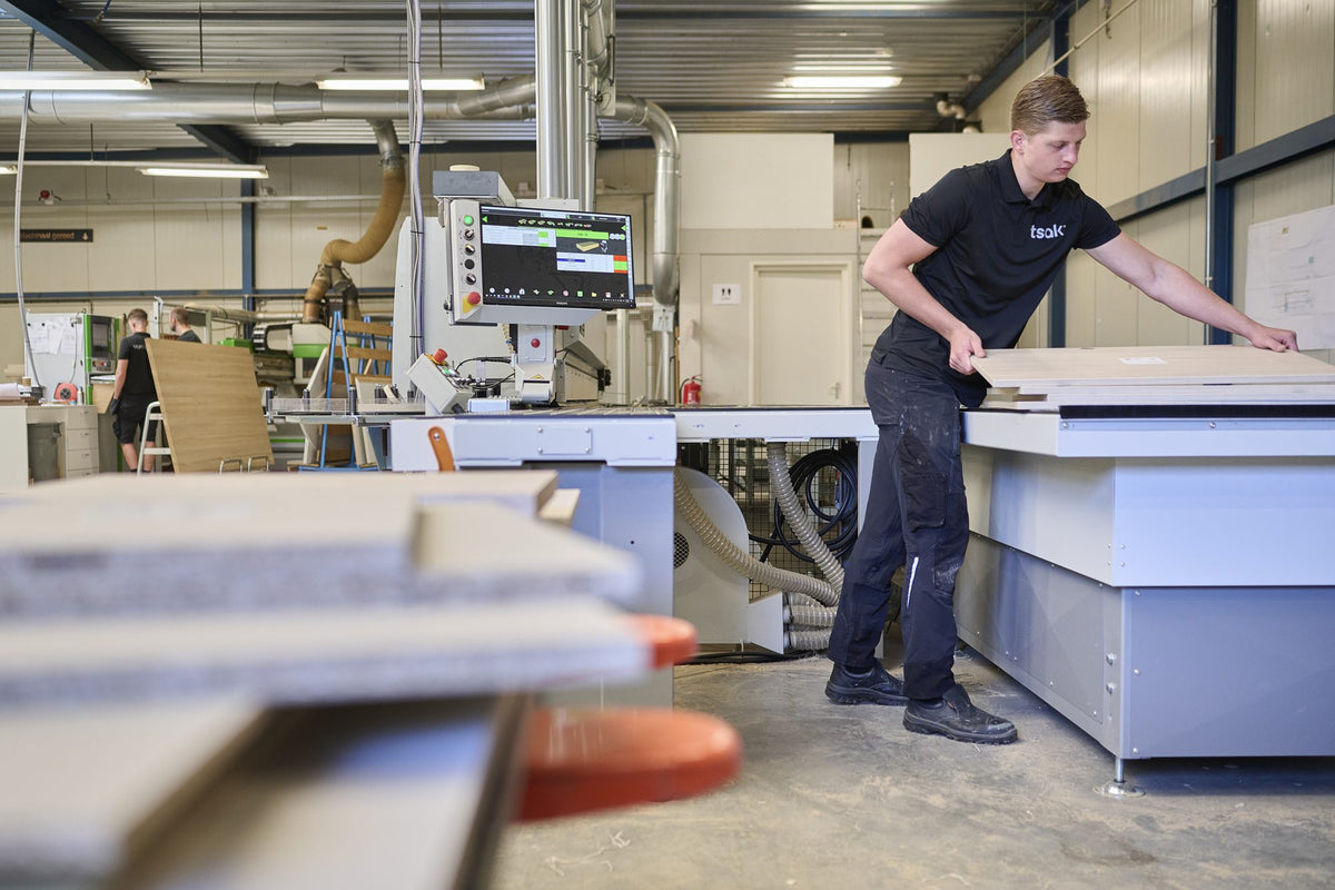 Tsak-medewerker legt panelen op de machine in de werkplaats